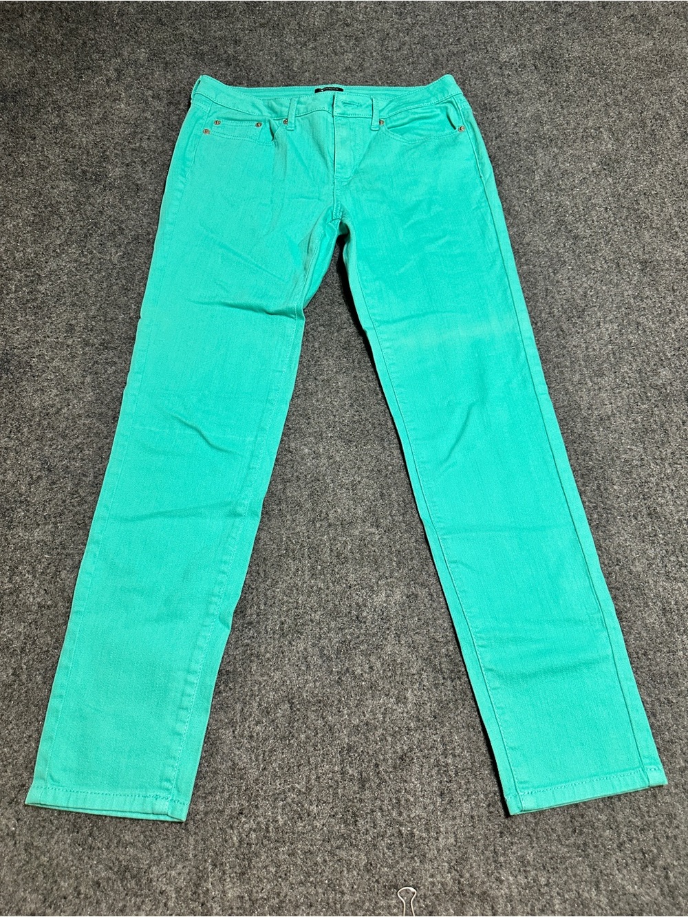 The item in the image is a pair of mint green slim-fit denim pants.
